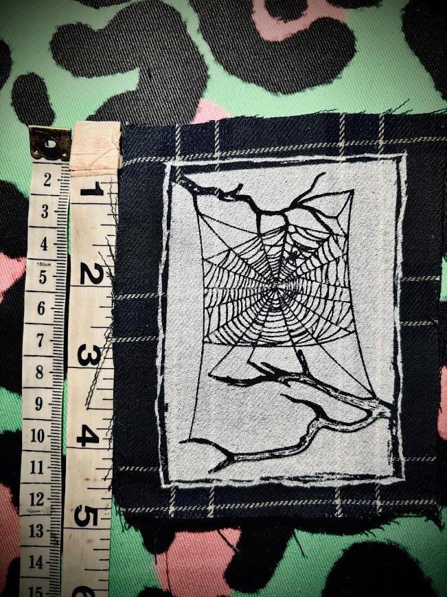 Spider web, stung up between two dead branches sew on patch