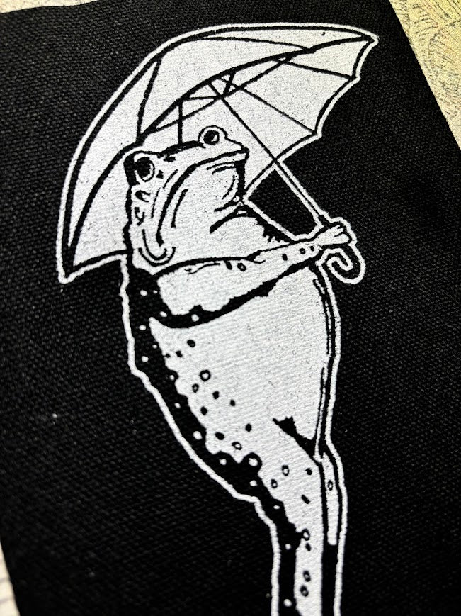 Sad frog holding an umbrella in the rain sew on patch.