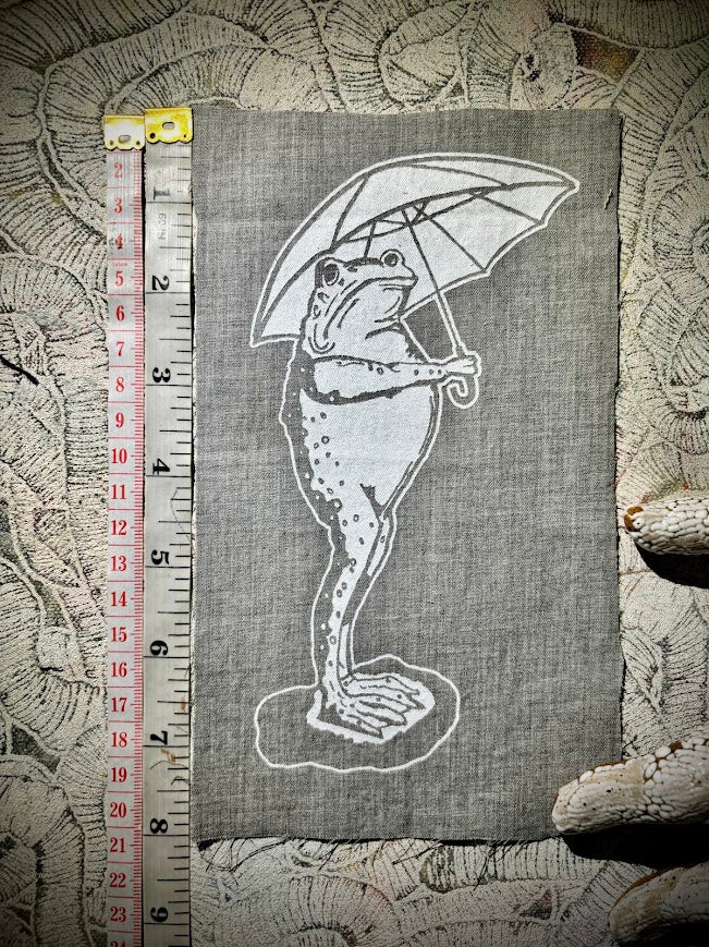 Sad frog holding an umbrella in the rain sew on patch.