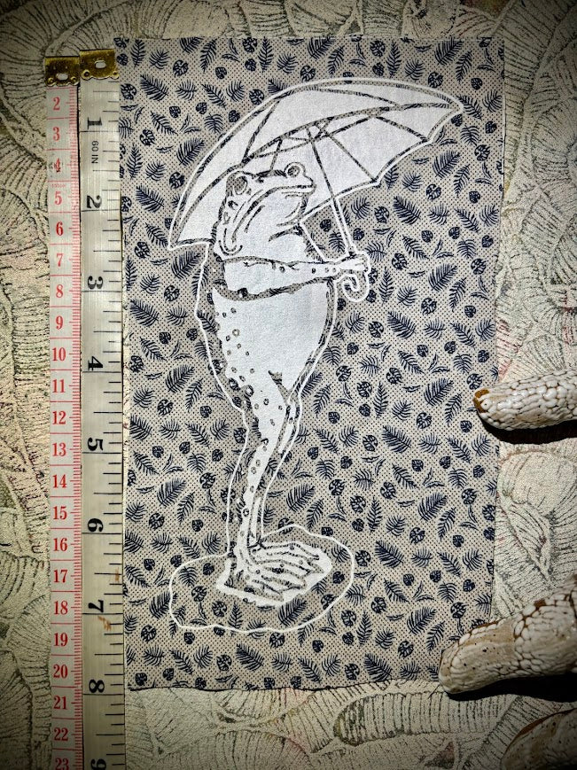 Sad frog holding an umbrella in the rain sew on patch.