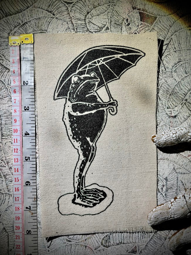Sad frog holding an umbrella in the rain sew on patch.