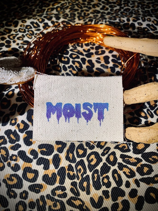 Moist mini patch. it says moist in a wet drippy font